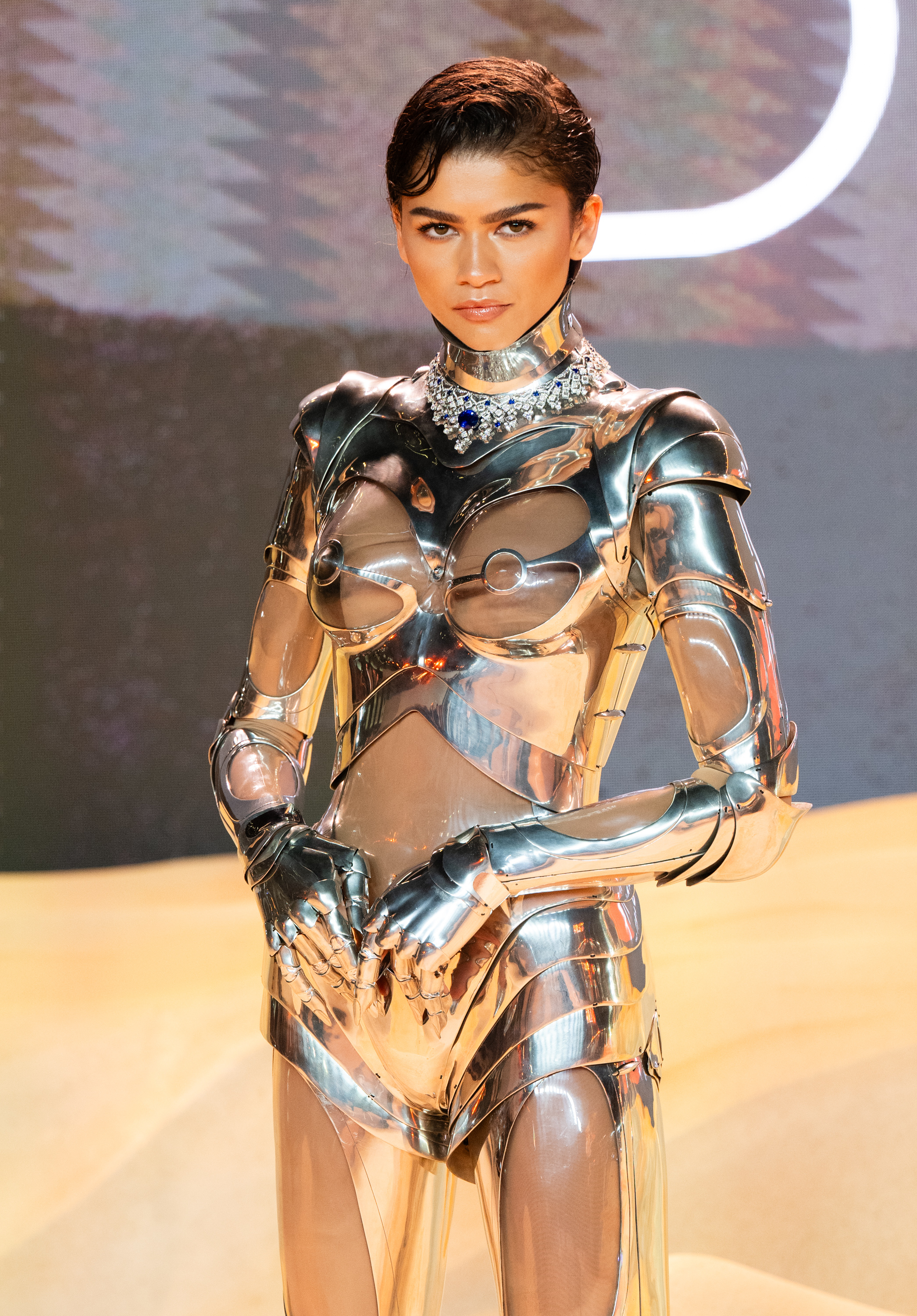 Person in a futuristic metallic costume with structured shoulders and a high neckline