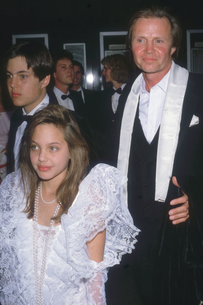 Angie in a lace dress as a young girl with her father, Jon Voight
