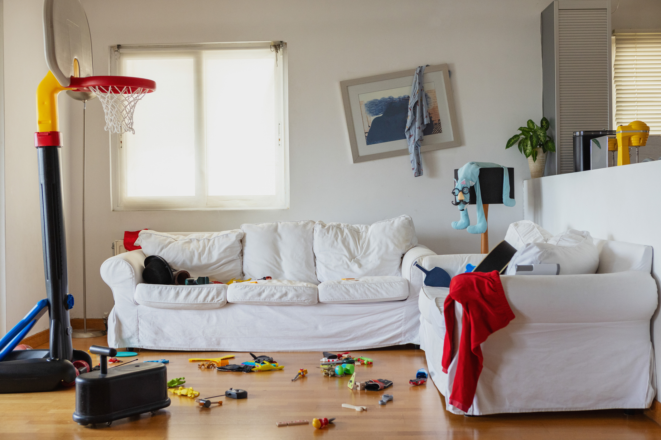 Living room with scattered toys and a basketball hoop, depicting a family space