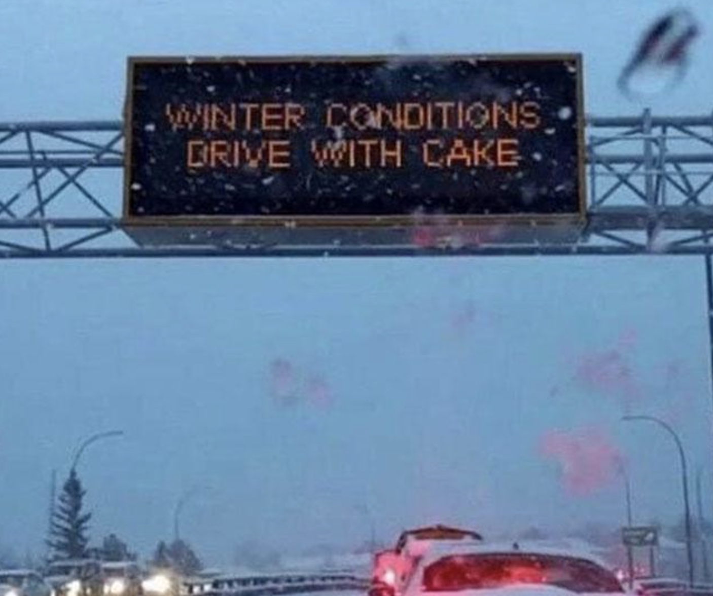 Road sign reads &quot;WINTER CONDITIONS DRIVE WITH CARE&quot;  but it looks like it says cake instead of care