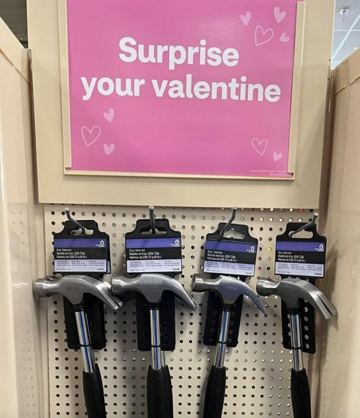 Store display with a sign saying &quot;Surprise your valentine&quot; above a selection of hammers