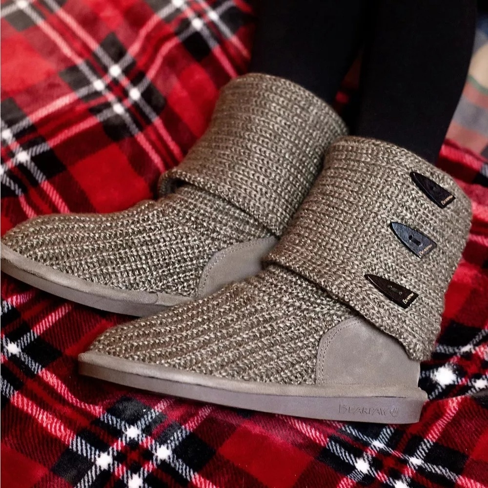 model wearing tan colored textured knit ankle boots on a plaid background