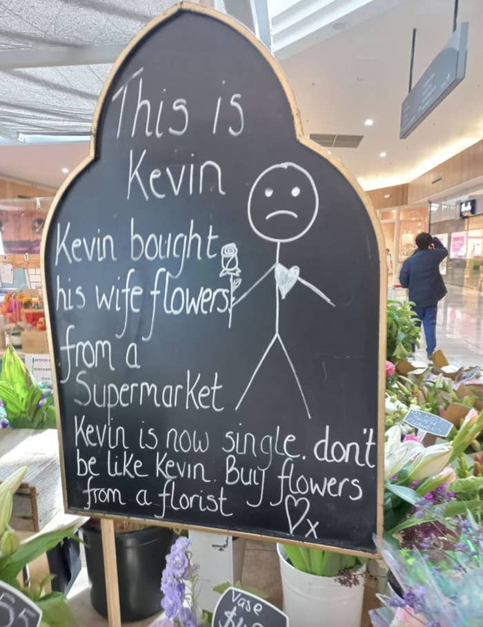 Chalkboard with a message encouraging buying flowers from florists instead of supermarkets, accompanied by a simple drawing of a person