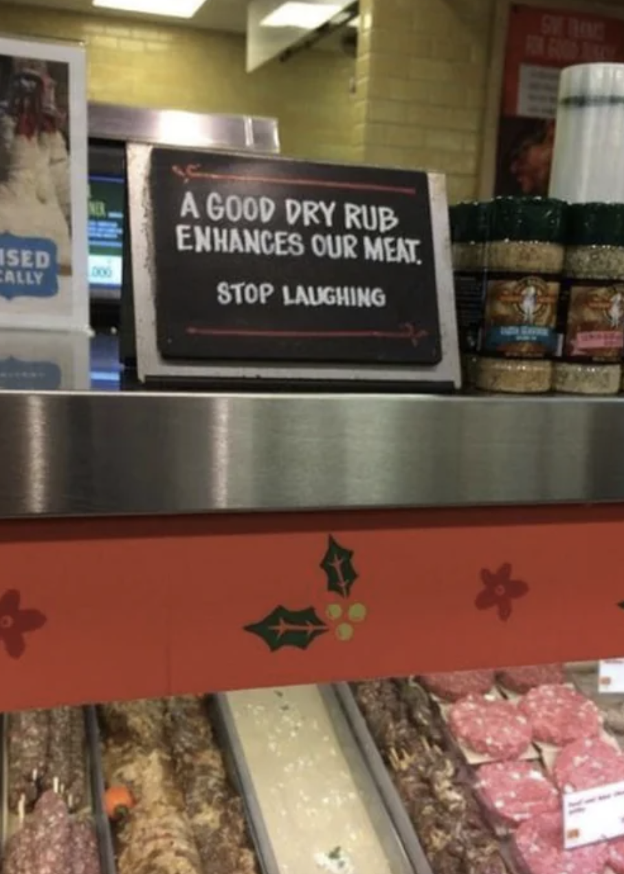 Sign at a meat counter reads: &quot;A GOOD DRY RUB ENHANCES OUR MEAT. STOP LAUGHING.&quot;