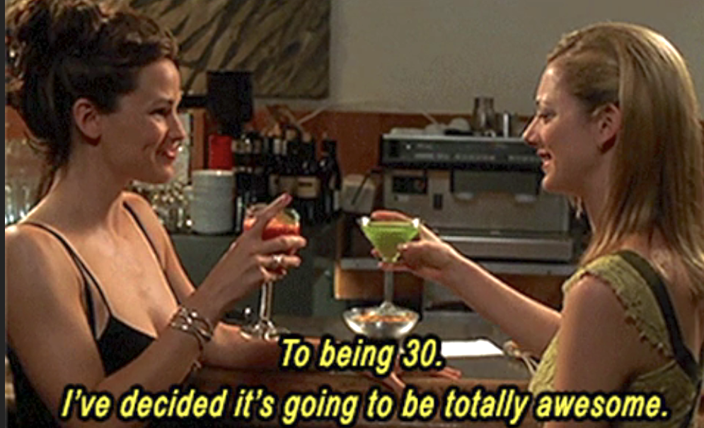 Two women are toasting with drinks, smiling, with text "To being 30. I've decided it's going to be totally awesome."