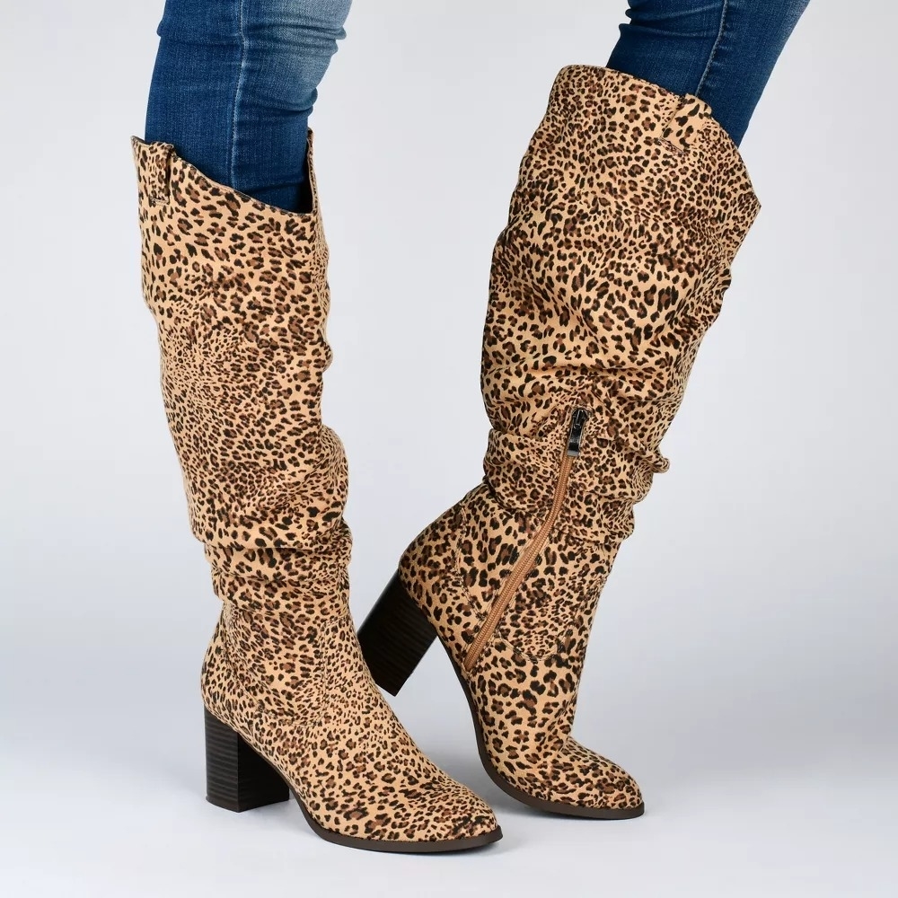 model wearing leopard print knee-high boots with block heels