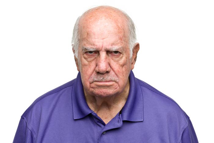Elderly man with a stern expression wearing a collared shirt