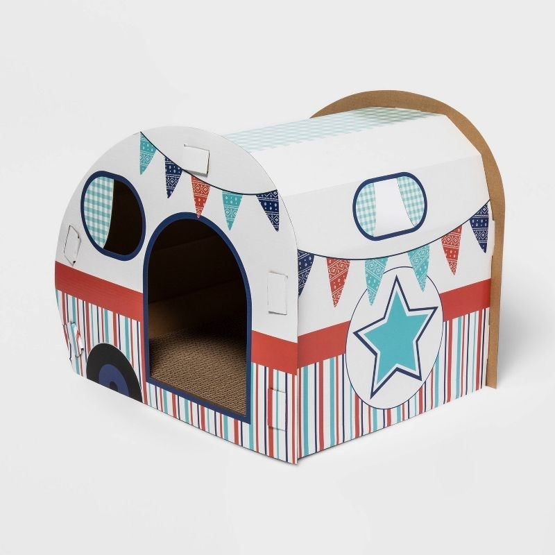 cardboard scratch house designed like a caravan, with a striped pattern and star motifs