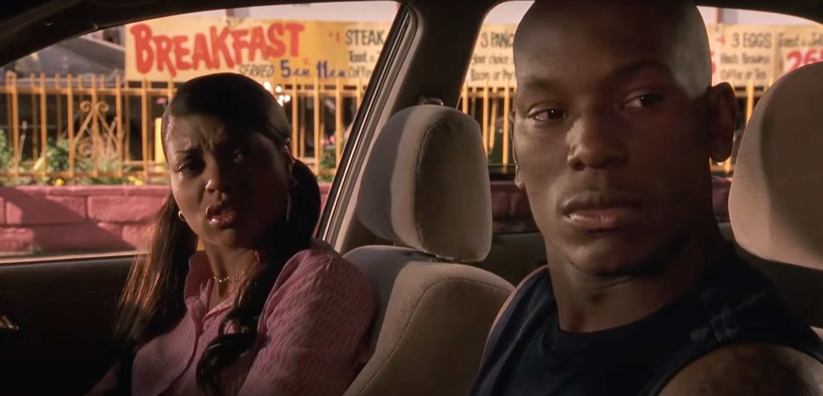Two actors in a car, the woman looks concerned and the man pensive, in a dramatic scene