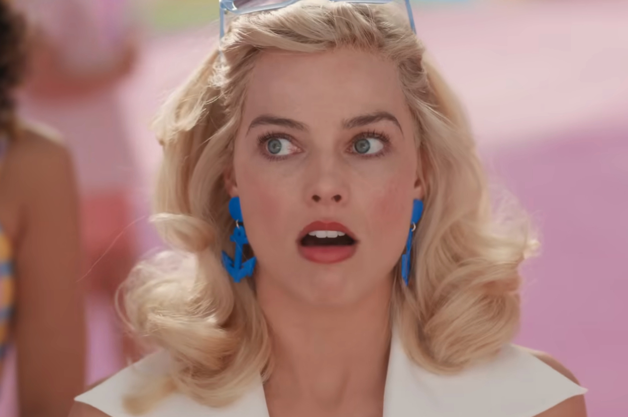 Margot Robbie as Barbie with surprised expression and blue earrings