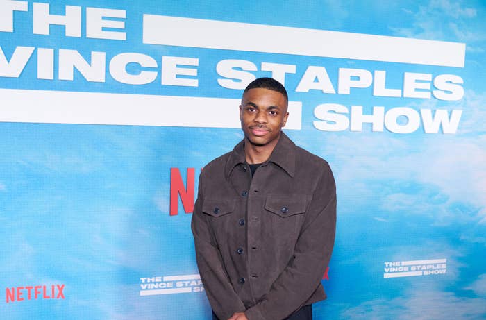 Man in dark casual jacket stands before a backdrop with text &quot;The Vince Staples Show&quot; and Netflix logos