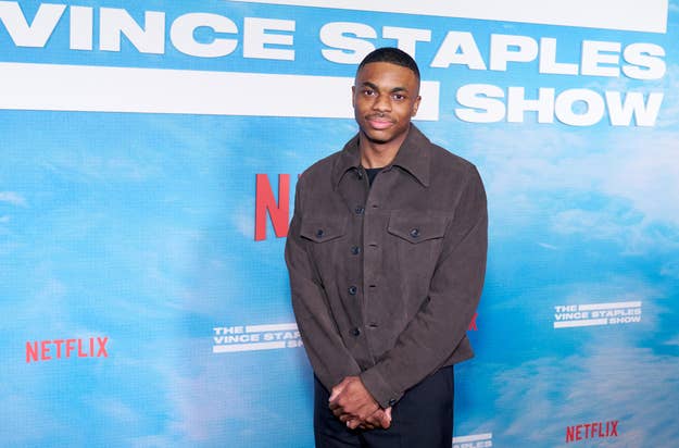 Man in dark casual jacket stands before a backdrop with text "The Vince Staples Show" and Netflix logos