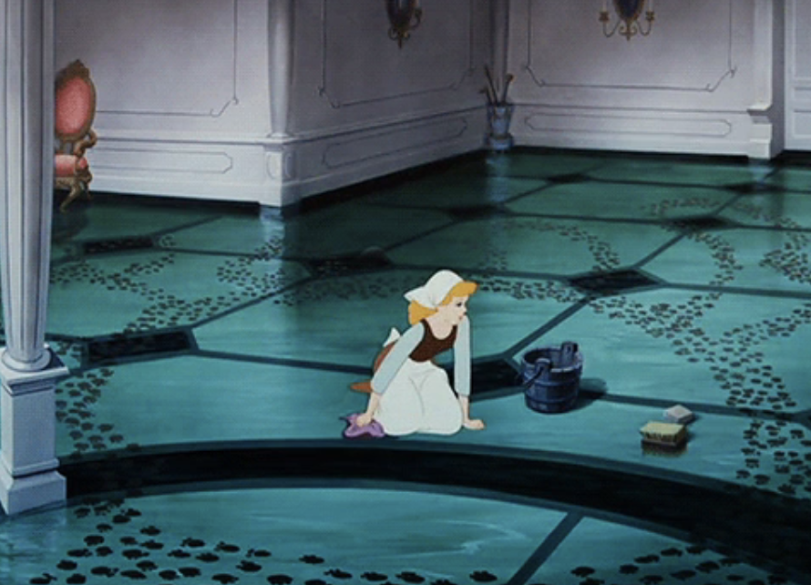 Cinderella in a maid outfit kneeling on the floor next to a bucket and scrub brush, looking distressed