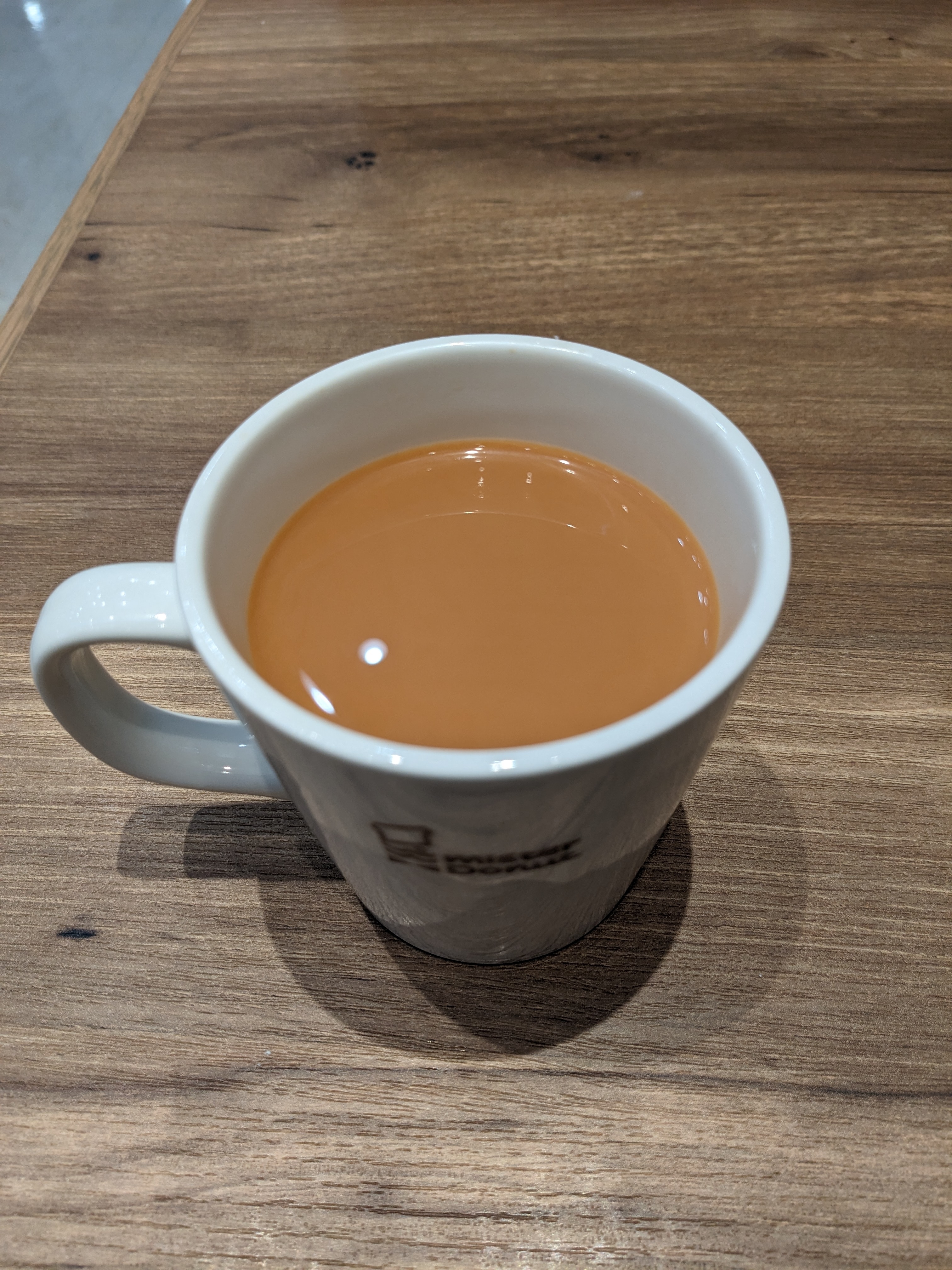 テーブルの上に置かれた白いマグカップに入った紅茶。