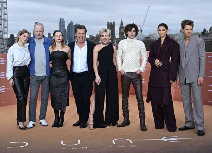 Cast of &quot;Dune: Part Two&quot; posing together; actors in stylish, varied formal wear on promotional event backdrop