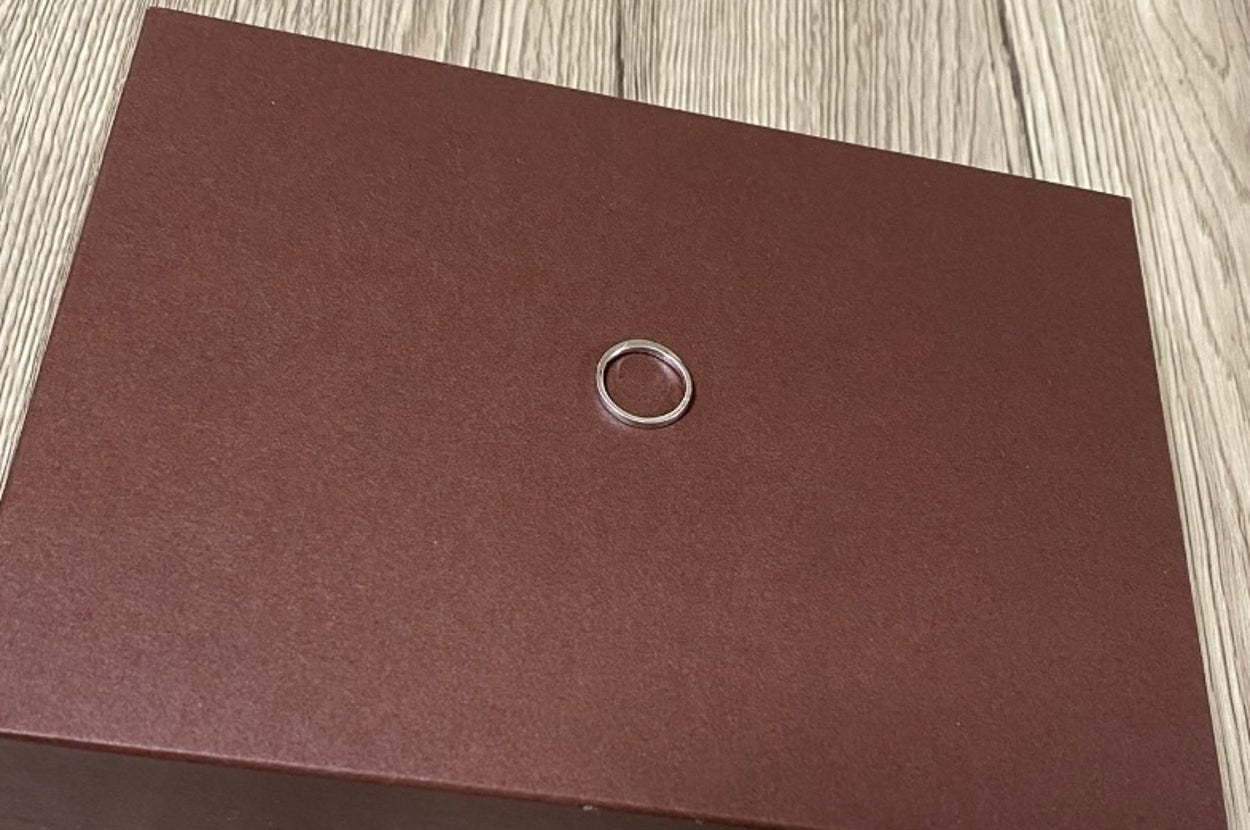 茶色の箱の上に指輪が置いてあります。
