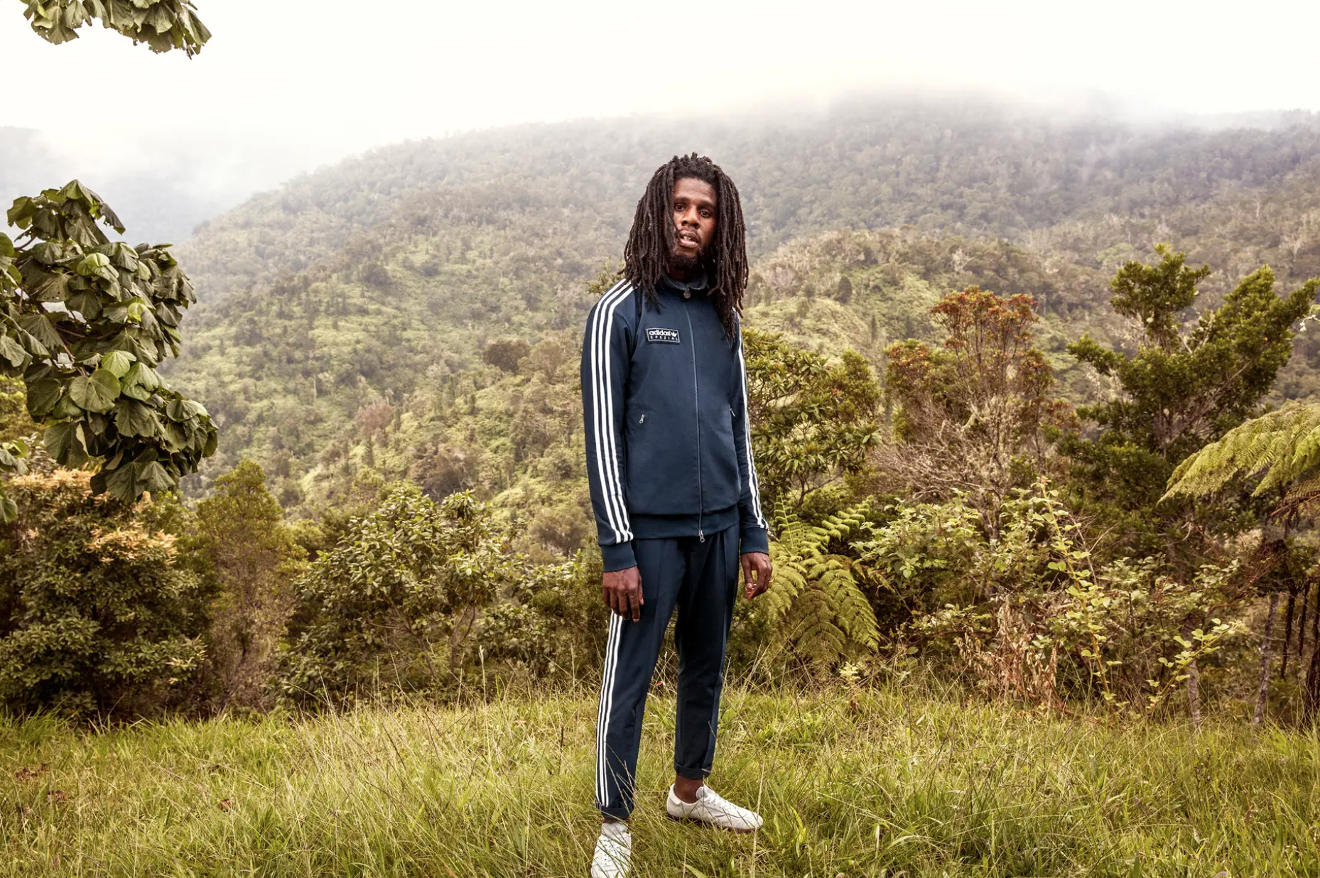 Person in athletic wear with sneakers standing in a forest clearing