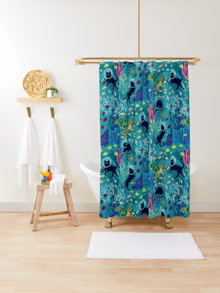 Shower curtain with abstract animal print in a bathroom setting, next to towels and a stool