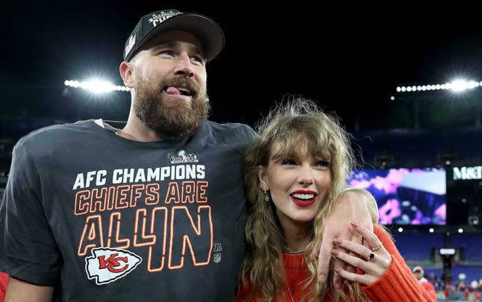 Travis Kelce in a Chiefs t-shirt with Taylor Swift smiling in a knit top at a football game