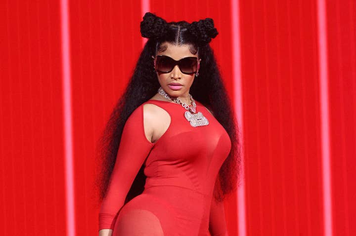Nicki Minaj poses in a fitted red outfit with sunglasses