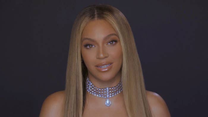 Beyoncé smiling at the camera, wearing a sparkling choker necklace