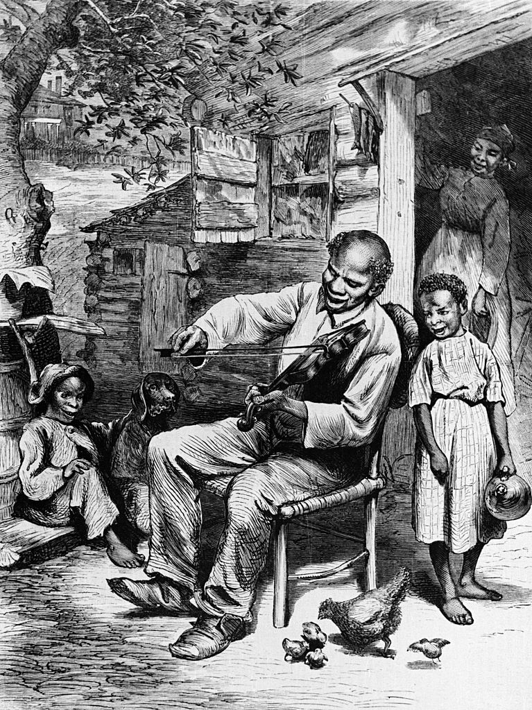 An elderly man plays a banjo, entertaining children and a woman on a rustic porch