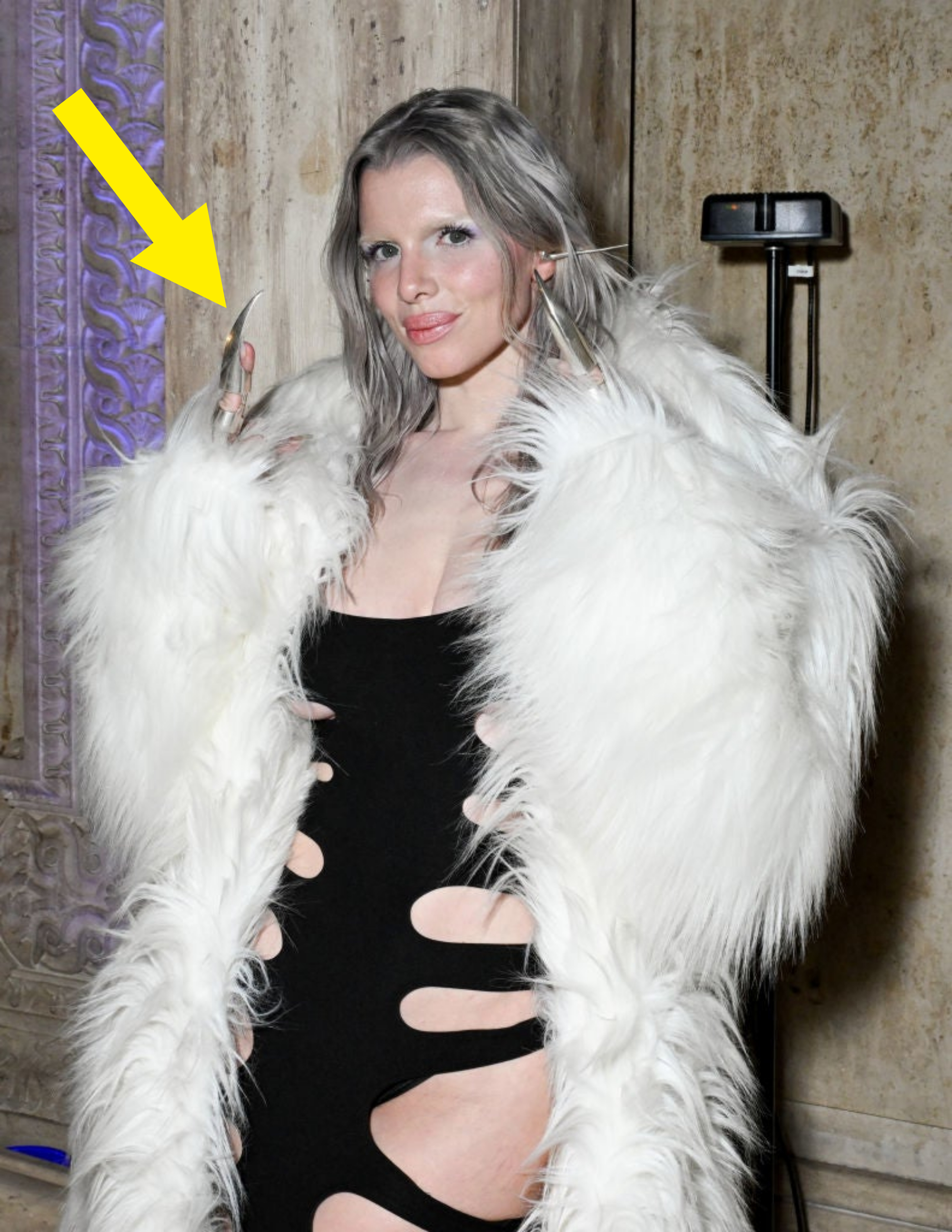 Julia posing with white fur coat and black dress with cut-outs