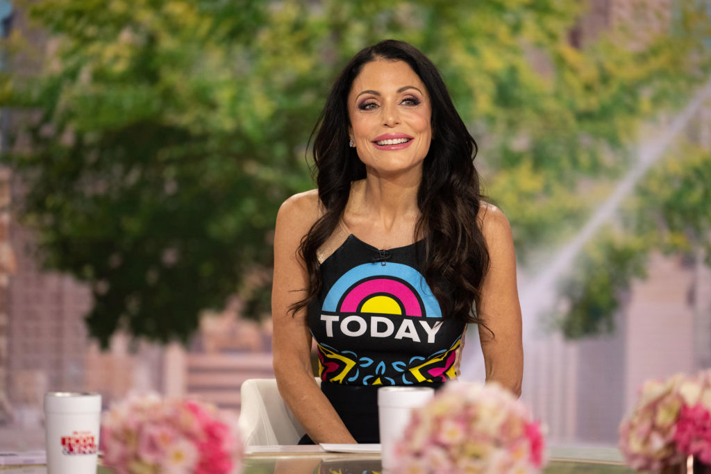 Bethenny in &quot;TODAY&quot; show themed top seated at a desk with floral arrangements, smiling