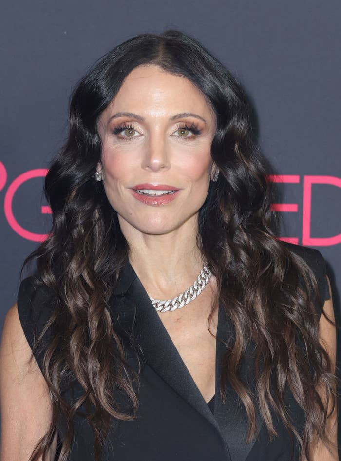 Bethenny in a black dress with wavy hair and a silver necklace at an event