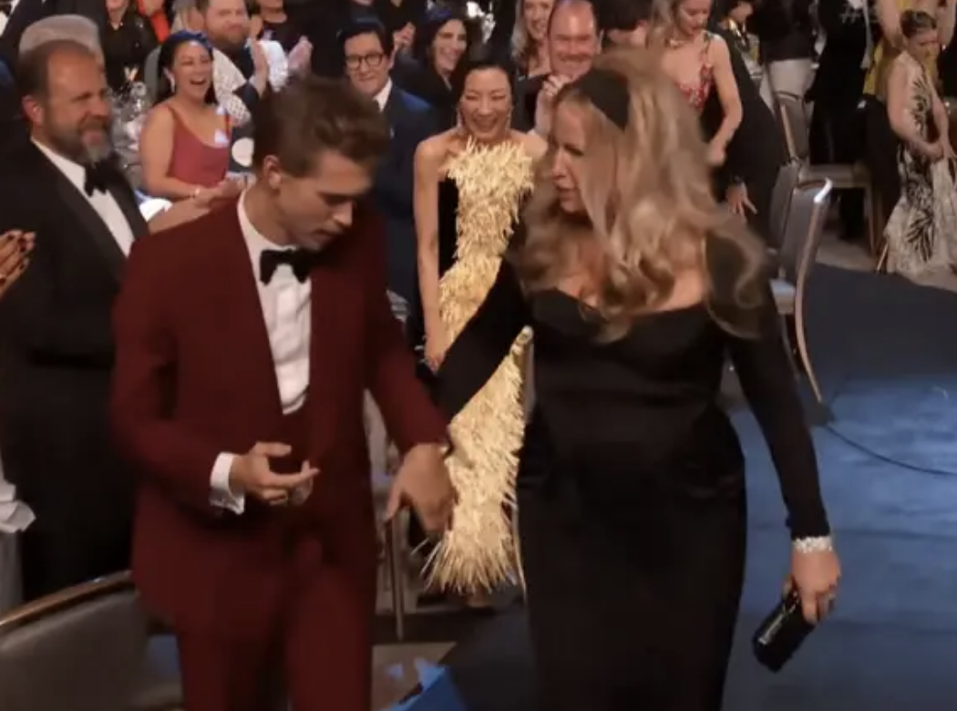 Austin Butler helping Jennifer Coolidge to the stage