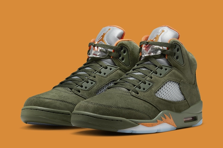 Pair of green high-top sneakers against an orange background
