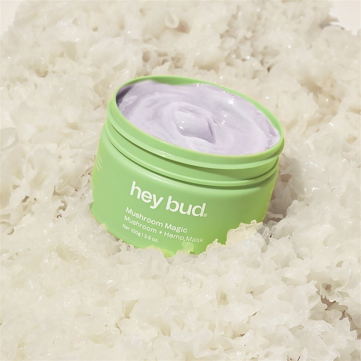Hey Bud skincare product container open displaying mask; surrounded by textured white material