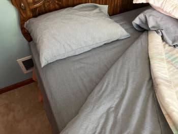 Unmade furniture with a pillow and crumpled linens