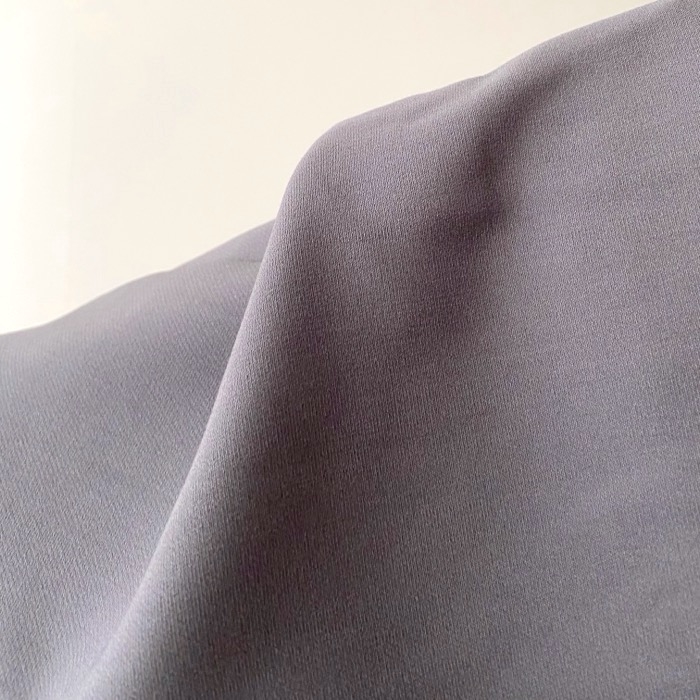 Close-up of a smooth fabric with a subtle sheen, likely a textile swatch