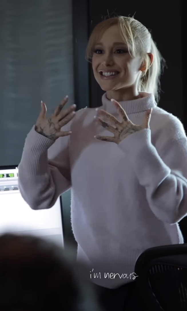 Close-up of Ariana wearing a sweater at the presentation and smiling with &quot;I&#x27;m nervous&quot; caption