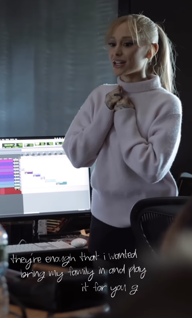 Close-up of Ariana wearing a sweater and standing by a computer