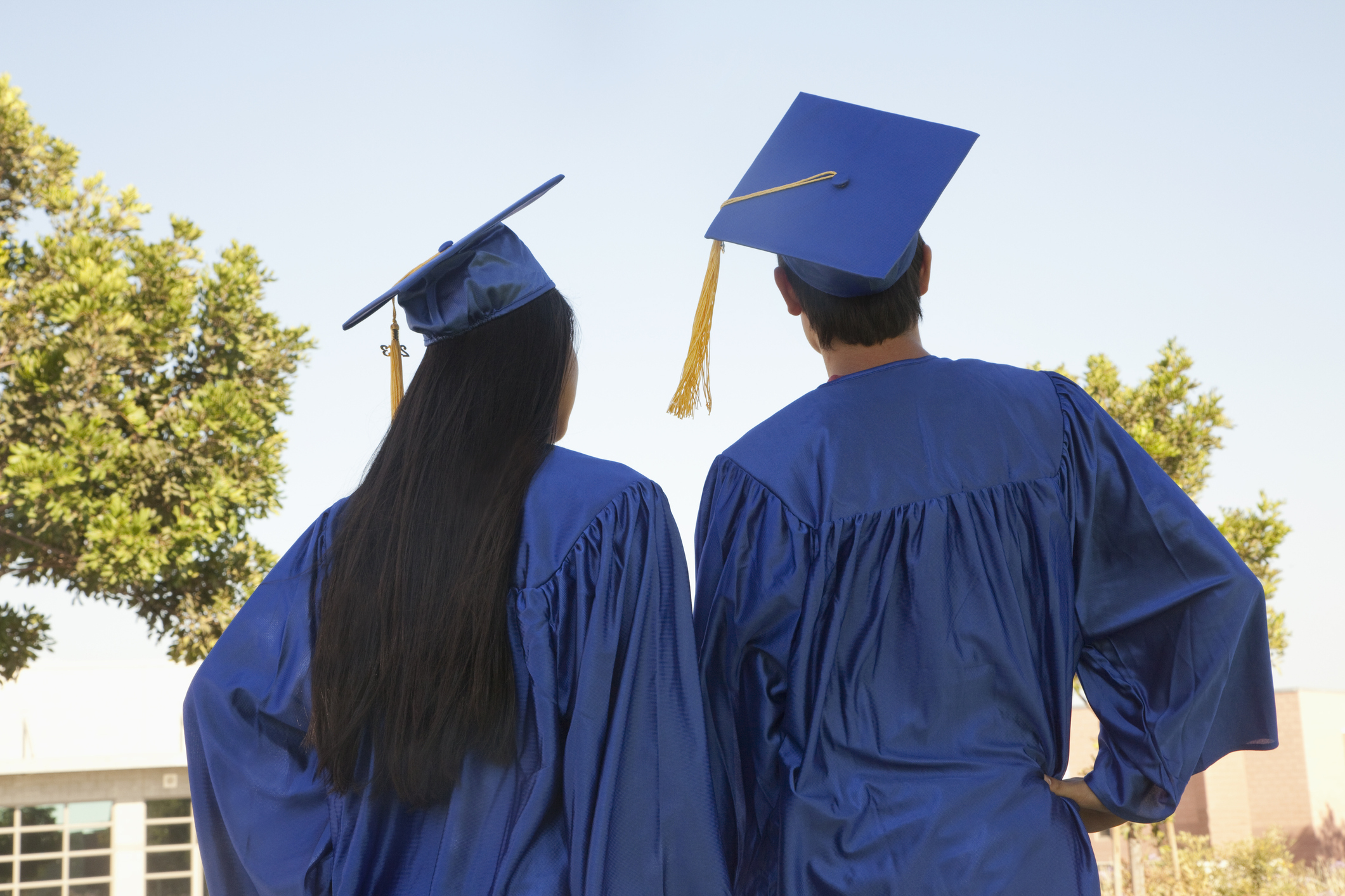 Young people wearing graduation caps and gowns