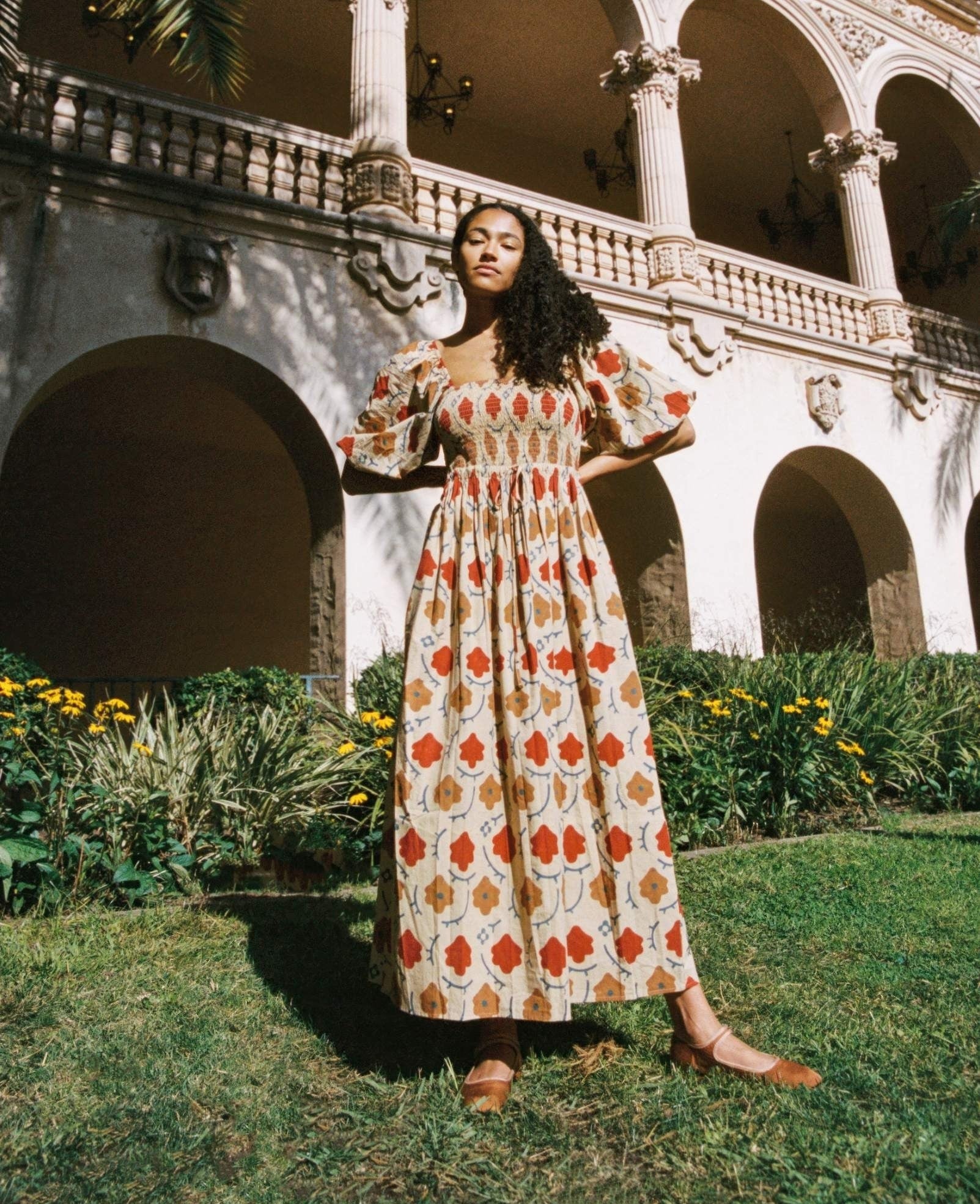 model wearing short sleeve maxi dress with a red and yellow floral print