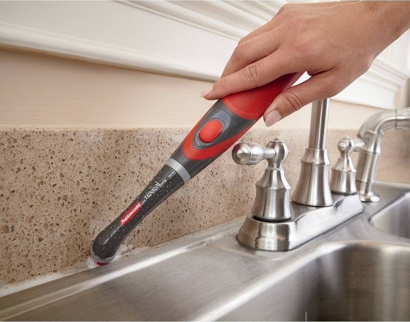 A scrubbing tool cleans grout