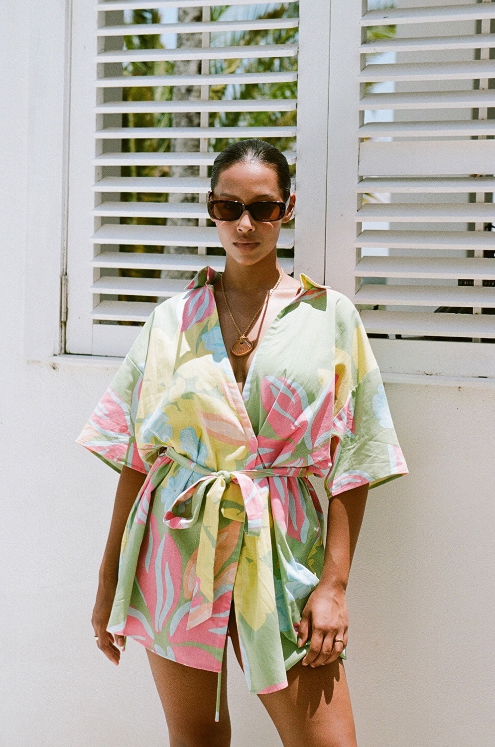 model wearing colorful floral-print wrap mini dress