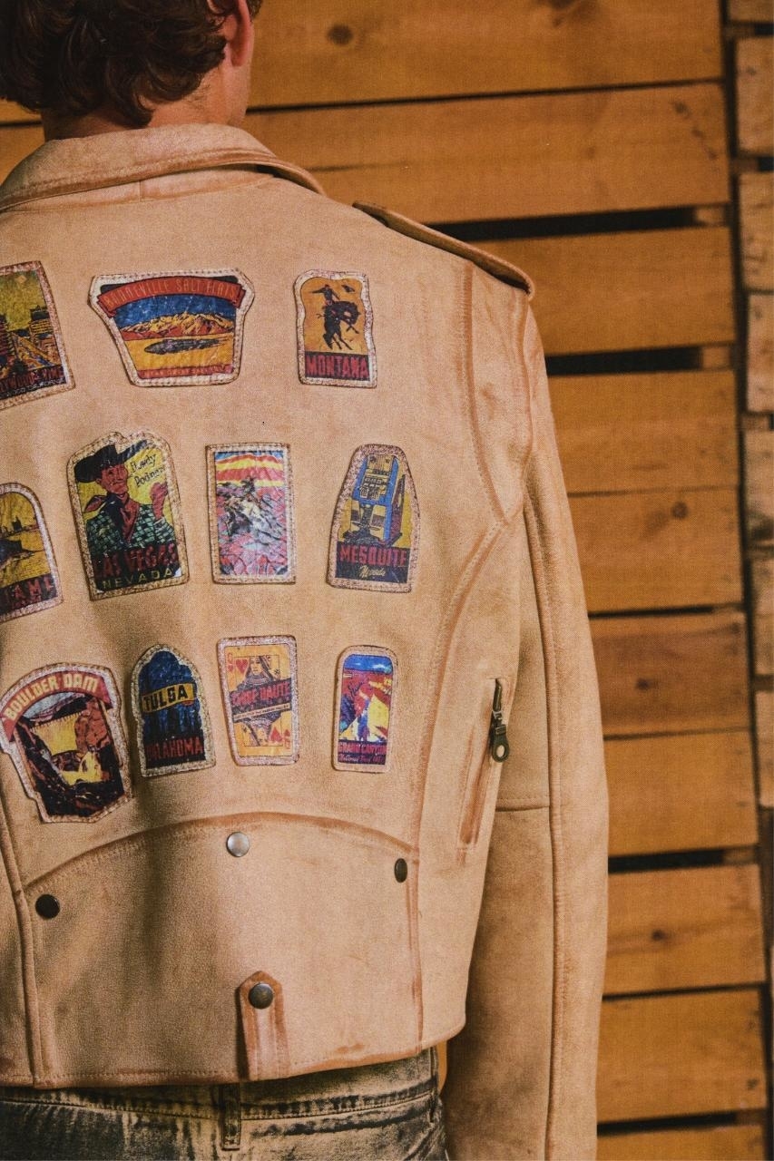 Person in a jacket with various colorful patches from different US states on the back