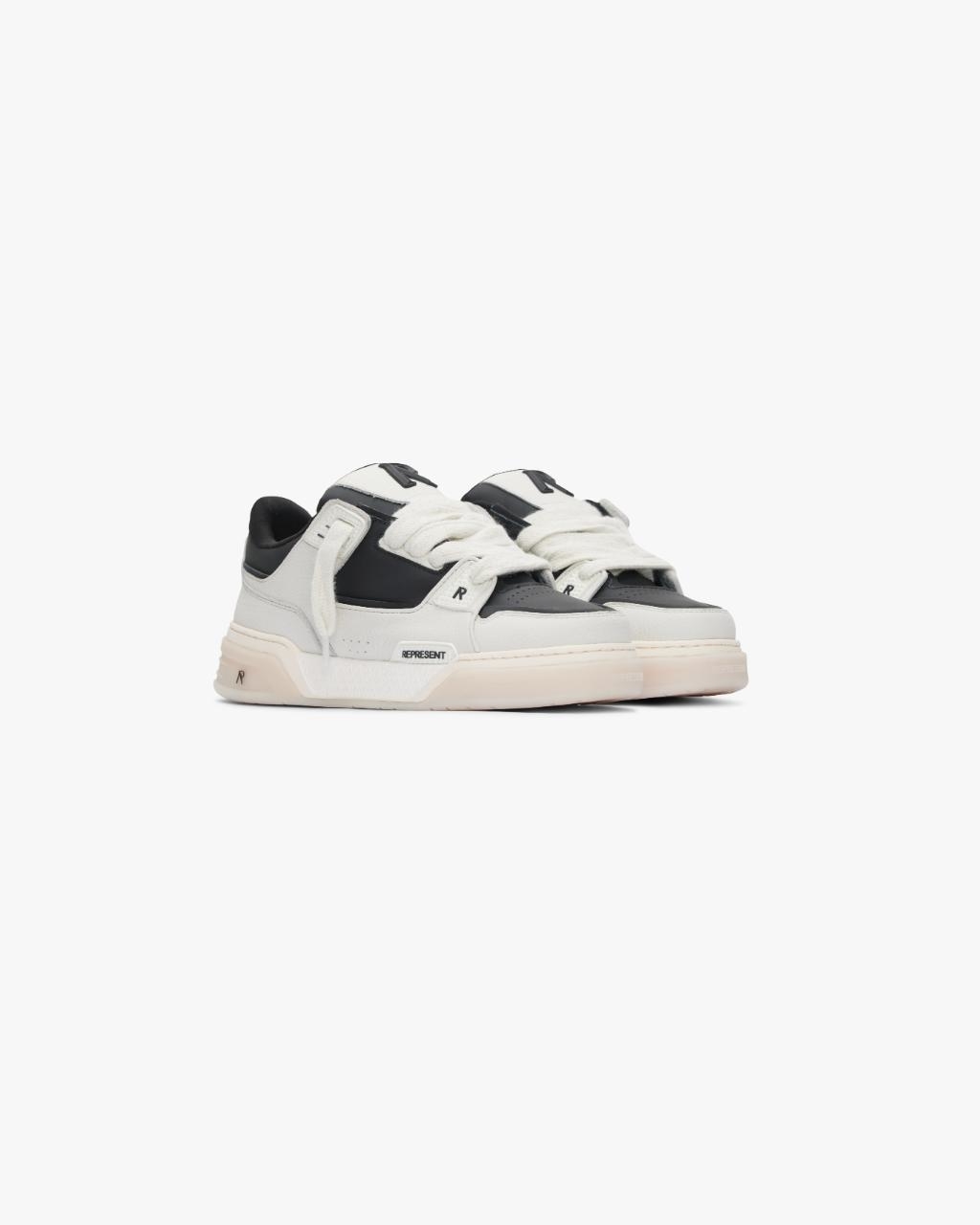 Givenchy sneakers with black and white design, low-top style, thick sole, displayed against a clear backdrop