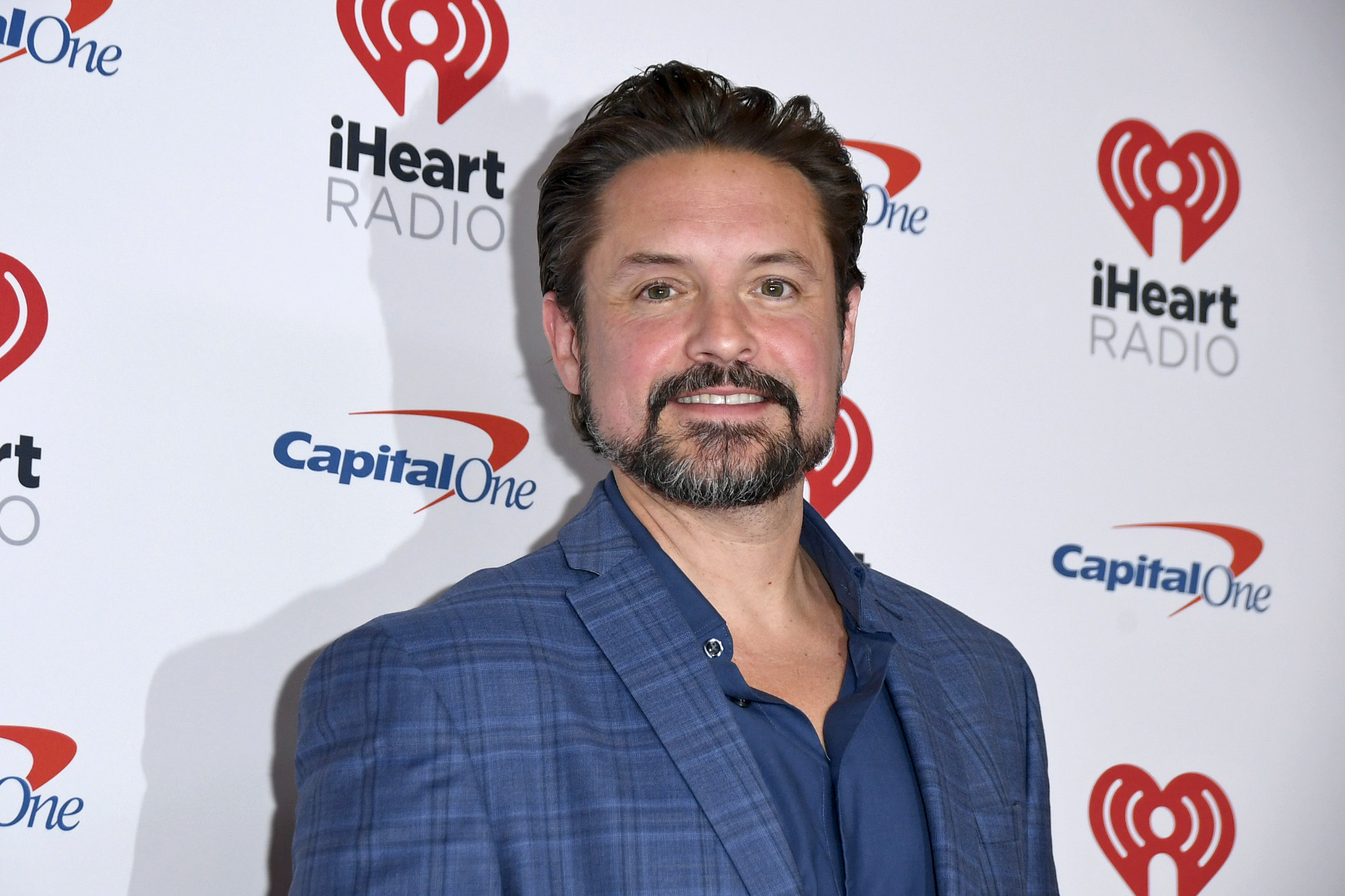 Man in blue shirt posing at iHeart Radio event