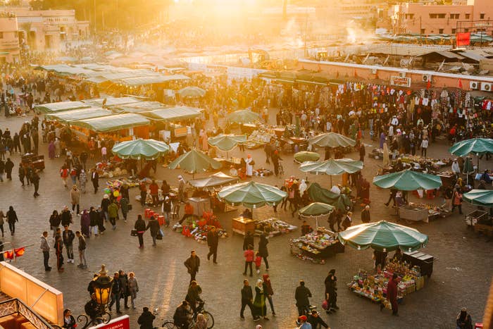 Busy outdoor marketplace with stalls and crowds at sunset