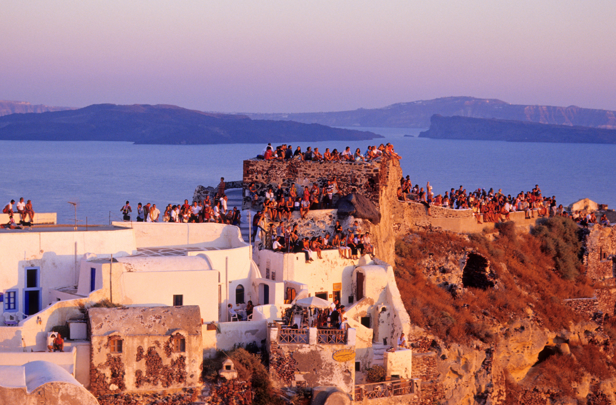 A crowd of people in Santorini watching the sunset