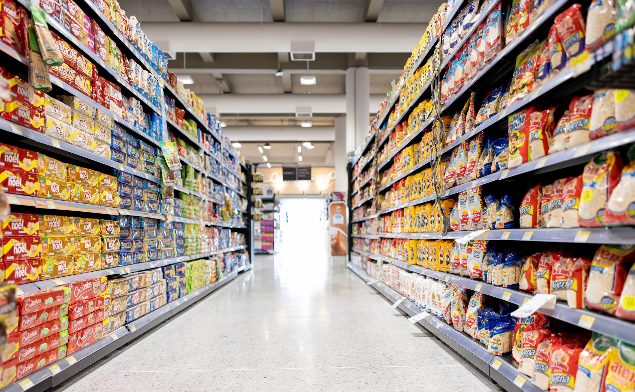 Grocery store aisle lined with shelves of packaged food items