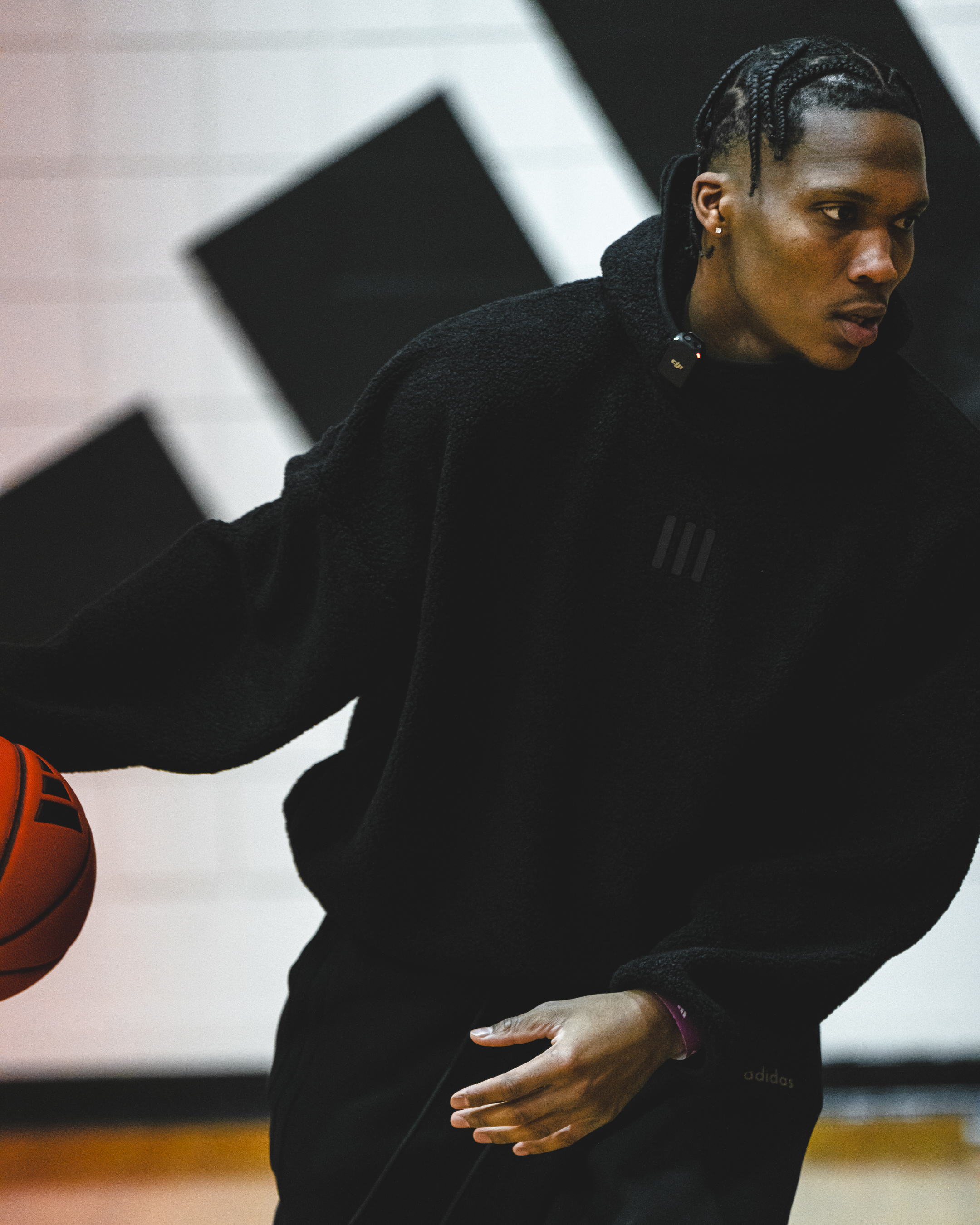Person in a dark turtleneck holds a basketball, focused on the game ahead