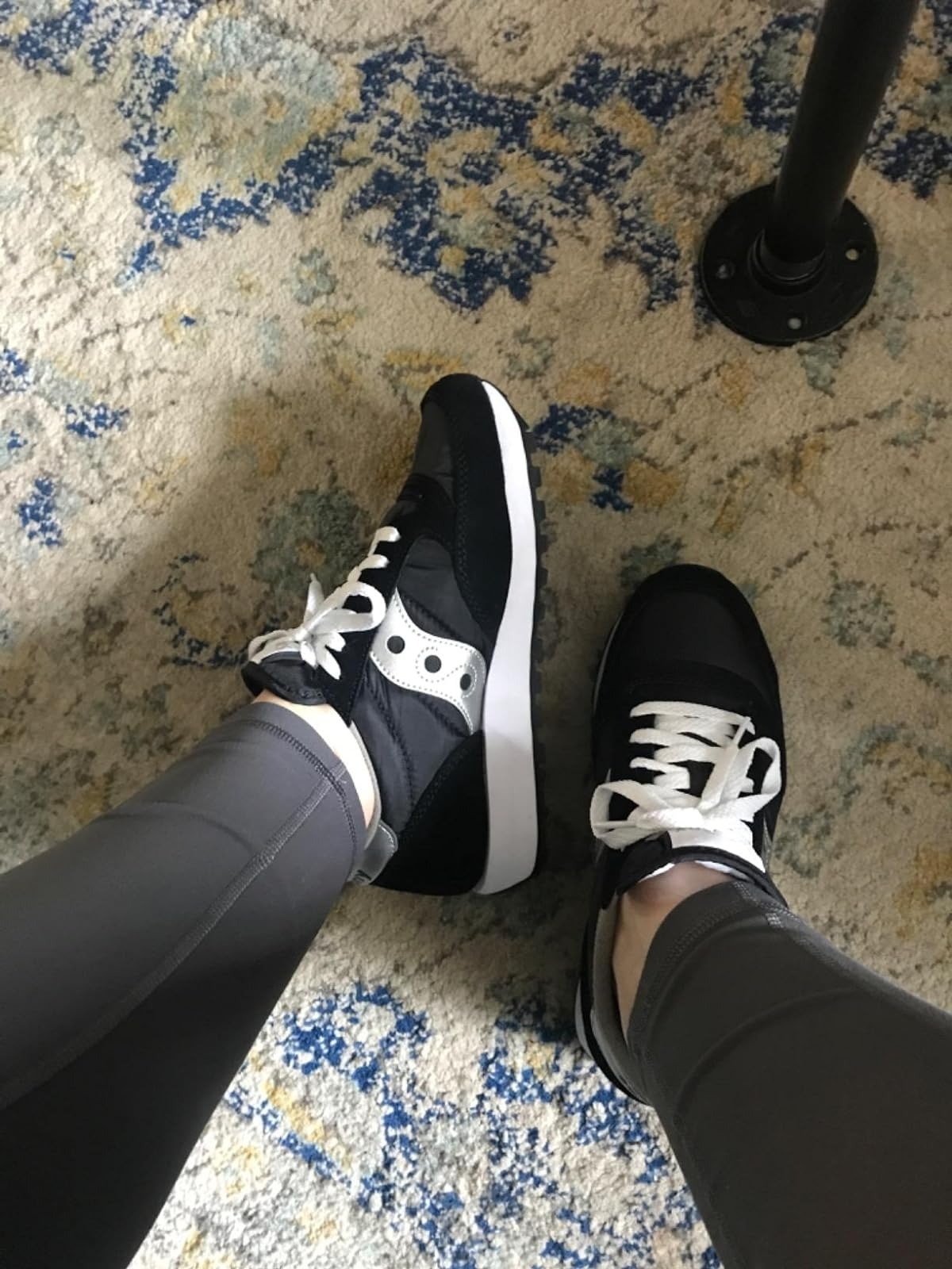 reviewer wearing black and white Saucony sneakers