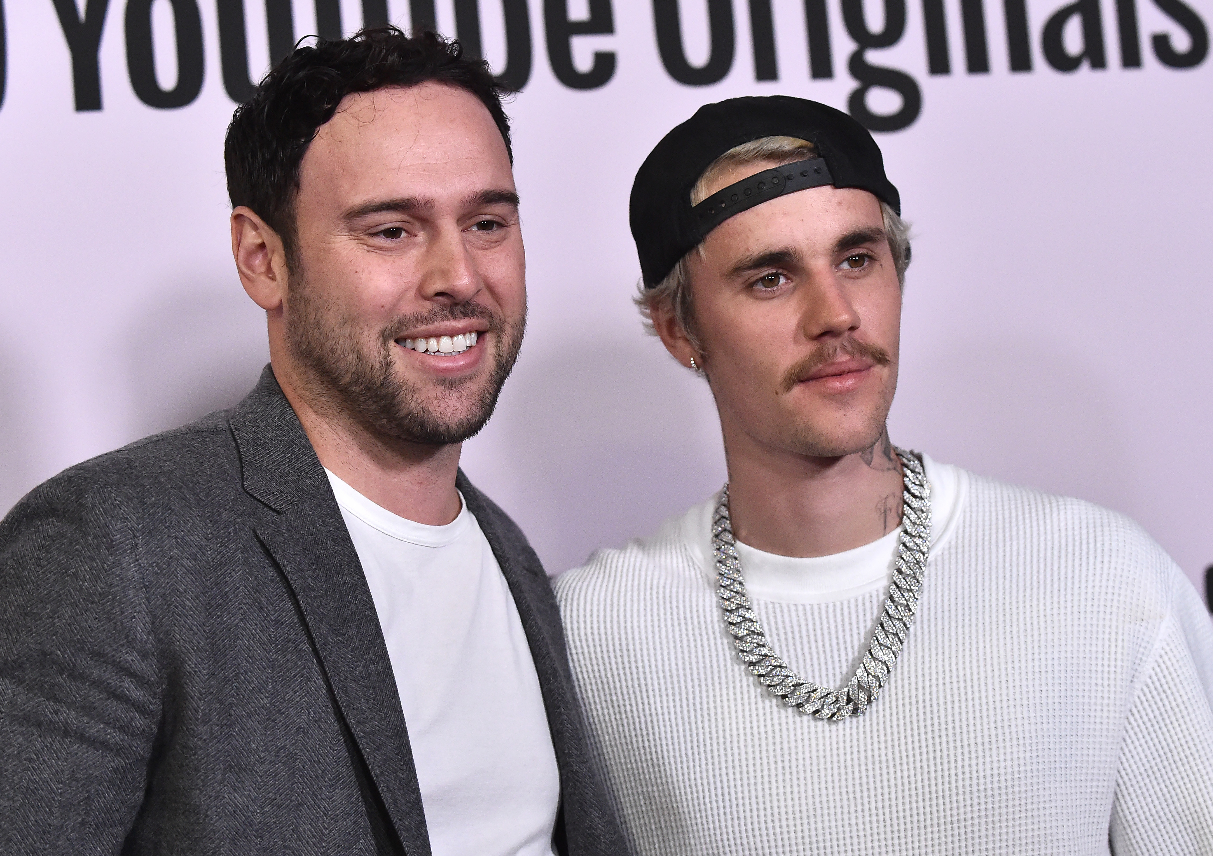 Scooter Braun and Justin Bieber smiling, Bieber in casual attire with a chain necklace