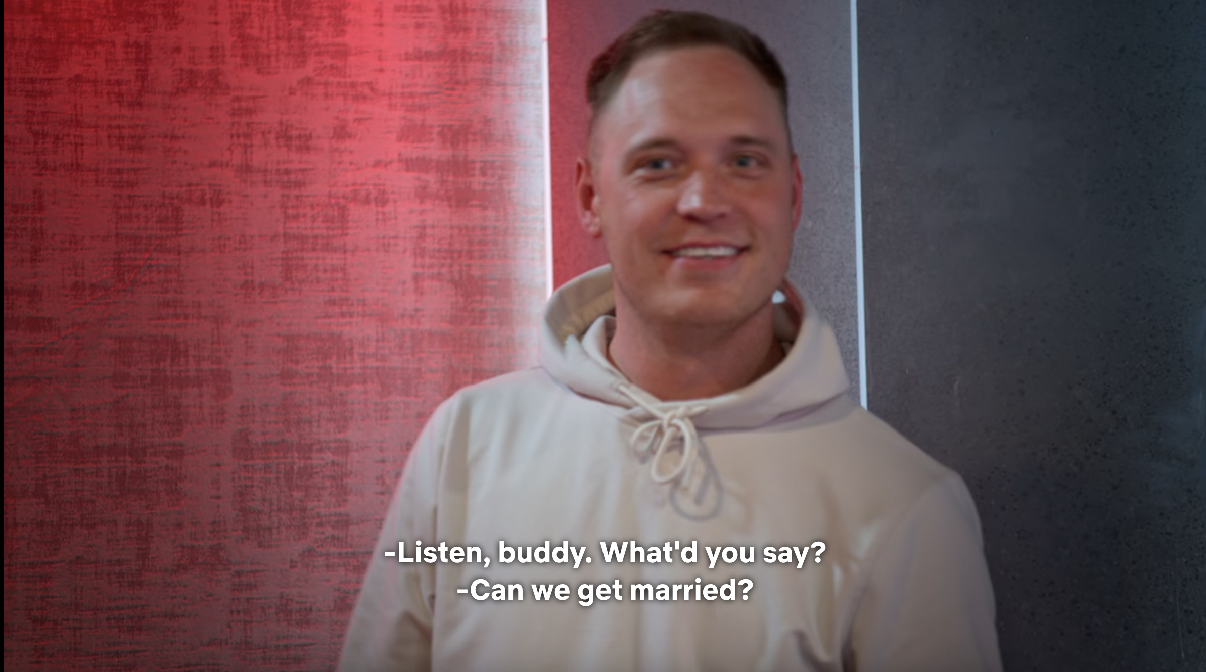 Man in hoodie smiling with subtitles &quot;Listen, buddy. What you say? Can we get married?&quot;